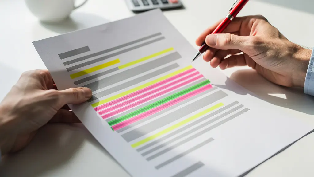 Mains tenant un contrat avec surligneurs colorés marquant différentes sections